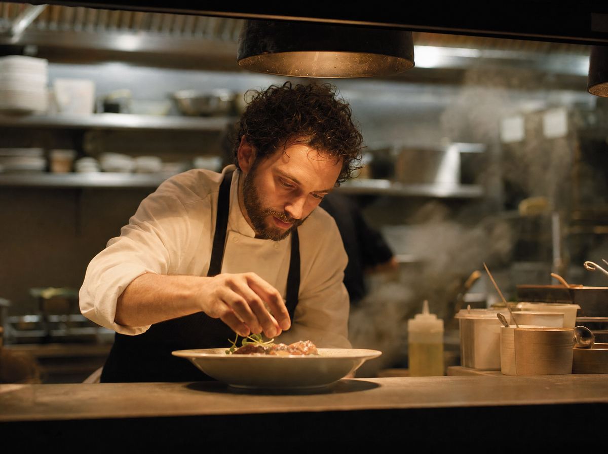 The chef plating a dish at the pass